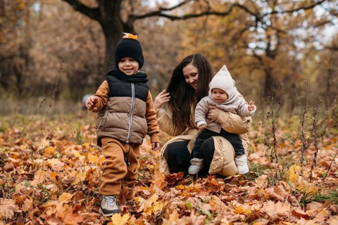 A joyful family enjoys an autumn day in the park, surrounded by colorful leaves. The warmth of the