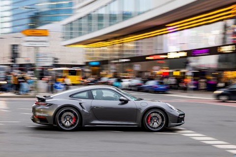 City view of Berlin in the evening with neon signs. Porsche out and about on Hardenbergstraße at