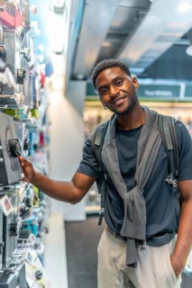 Vertical portrait of a handsome african young man in an electronics store