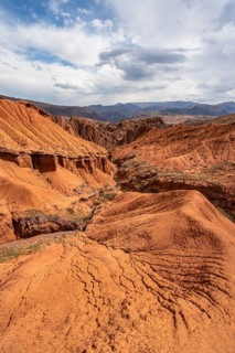 View of eroded mountain landscape with sandstone cliffs, canyon with red and orange rock