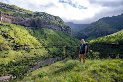 Young female hiker between mountains, Drakensberg National Park, KwaZulu Natal, South Africa