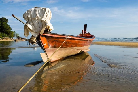 Longtail boat on the shores of Nai Yang Beach in the north of the Thai holiday island Phuket,