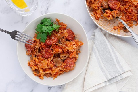 Bigos, Polish dish bigos, on the table, pan with stewed meat, with cabbage, chorizo sausages,