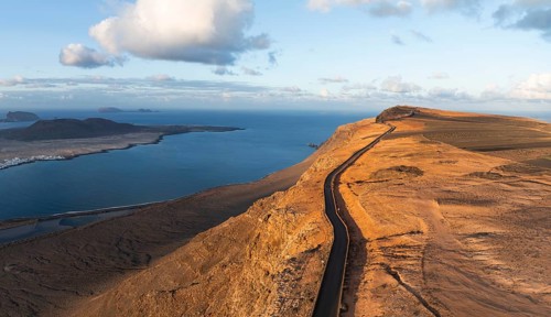 Road on cliffs in evening light, steep cliffs on the coast near Mirador del Porrito, aerial view,
