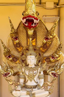 Meditating Buddha figure protected by a multi-headed snake, Buddhist temple complex Wat Phra That