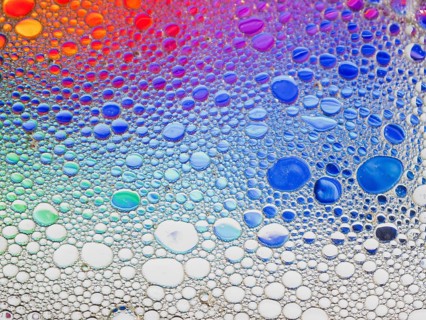 An abstract image featuring a vibrant array of colorful bubbles. The gradient transitions smoothly