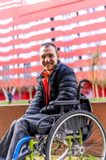 Happy man with disability sitting in wheelchair, enjoying sunny day outdoors, promoting inclusivity