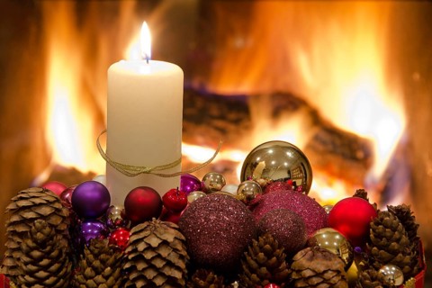 Christmas floral table decoration in front of the fireplace with candles