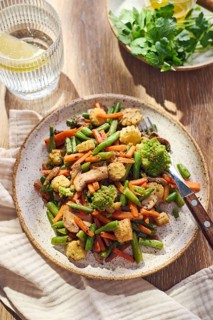 Plate of stir-fried mixed vegetables with green beans, carrots, baby corn, romanesco and mushrooms