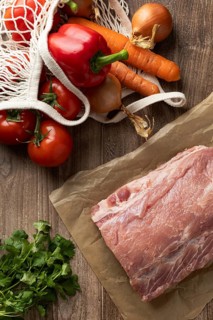 Top view of fresh vegetables and pork meat on wooden background, perfect ingredients for Hungarian