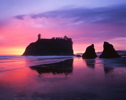 A breathtaking sunset paints the sky in shades of pink and purple at Ruby Beach, located in Olympic