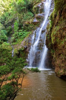 Beautiful waterfall among the dense vegetation of rainfoest and rocks in the state of Minas Gerais,