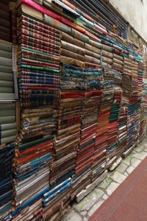 Stacked books on a wall after flood damage in a bookstore, Venice, Veneto, Italy