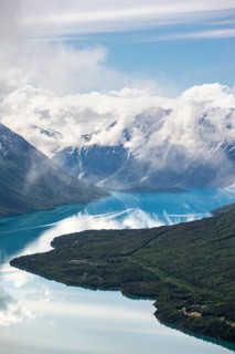 View of snowy mountains in spring and turquoise Kenai Lake with reflection, Slaughter Ridge Trail,