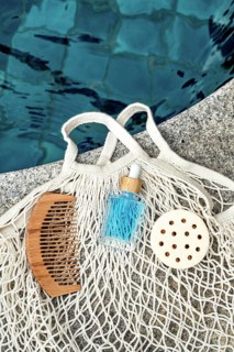 Top view image of a blue face care serum for men, set beside natural grooming tools, including a
