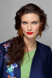 Beautiful lady with make-up, red lips and curly brunette hair. studio fashion shot on grey