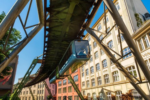 A suspension railway runs between old industrial buildings near the Kluse stop, Wuppertal, Germany