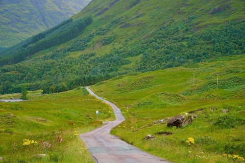 Narrow trail snakes through green hills and forests in picturesque mountain scenery, Loch Etive,