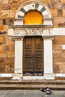 Decorated arched entrance door, historic city centre, Lucca, Tuscany, Italy