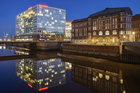 Modern mirror house and historic Ericus-Kontor at Ericusspitze at Blue Hour with reflection in the