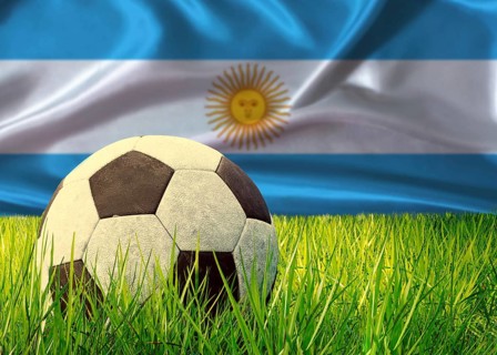 Soccer ball on the grass with Argentina flag in the background. Soccer ball on pitch against