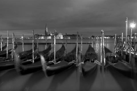 Nocturnal atmosphere with moving gondolas, San Georgio Maggiore in the back, Guidecca island on the