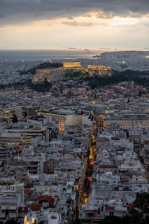 View over the sea of houses of Athens, illuminated Parthenon temple on the Acropolis, from Mount