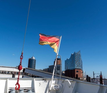 German flag on the bow of the museum ship Cap San Diego, Elbe Philharmonic Hall in the background,