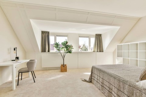 A sleek, modern bedroom featuring large windows, neutral color palettes, and minimalist furnishings