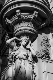 Female stone figure supporting a façade, black and white photograph, Graben pedestrian zone,