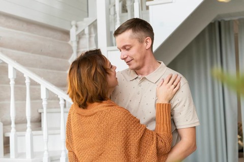 A heartwarming scene of a woman and man sharing a close, intimate moment in a beautifully decorated