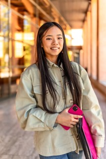 Vertical portrait of a happy beauty and young chinese woman at the university campus