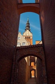 View through a passage to a Gothic church tower on a clear day, St Nicholas' Church, 13th century