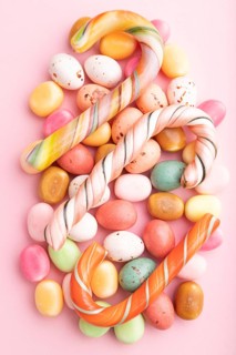 Various caramel candies on pink pastel background. close up, top view, flat lay