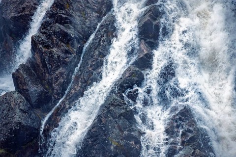 Detailed view of water cascading over rocky surfaces at Presa del Villar, Madrid, capturing the