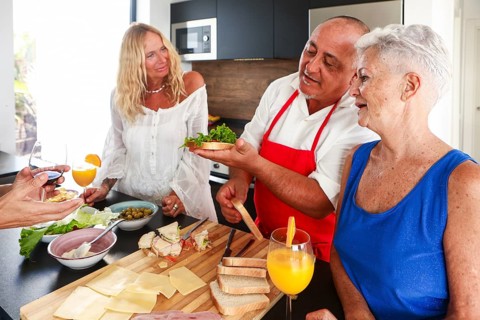 Joyful seniors gather at a vibrant kitchen party, sharing stories and laughter while indulging in