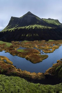 The breathtaking Icelandic Highlands showcase majestic dark mountains and lush green moss,