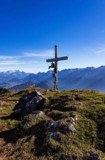 Old summit cross on the Schwarzer Berg with a view of the Lammertal valley and Dachstein massif,