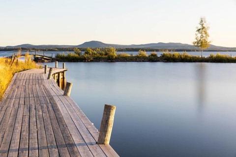 Wide wooden walkway at Lake Siljan near Nusnäs, mountains in the background, Dalarnas län, Sweden