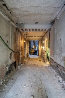 Industrial construction site interior under renovation. Exposed bricks, wires, and machinery create