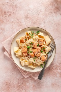 Tagliatelli pasta, with salmon slices and herbs, on a decorative plate, homemade, no people