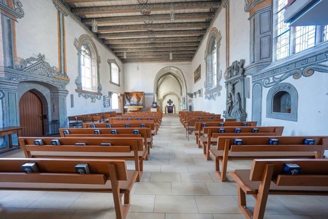 A clearly structured interior of a church with religious books on the benches, Deufringen,