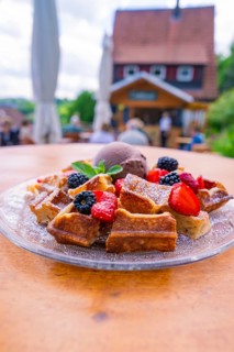 Waffles with berries served on a terrace in summer with a picturesque backdrop, Cafehäusle Calw,