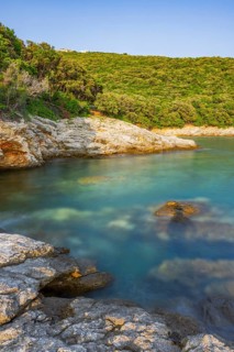Crystal clear and turquoise water on the beach of Ustrine Bay on a sunny day at sunset on the
