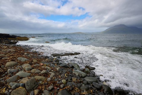 Stone beach on a cloudy day with waves and mountains in the background, Elgol Beach, Elgol, Isle of
