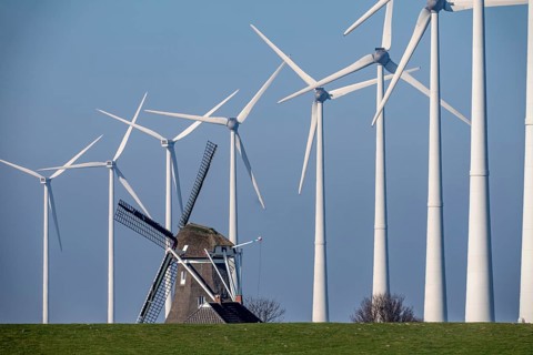 Poldermolen De Goliath windmill stands between the high-tech wind turbines in Eemshaven, historic