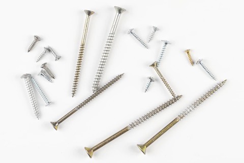 Different screws in different sizes on a white background