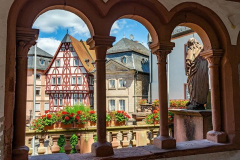 View through the arches of the Abbey Basilica of the reconstructed half-timbered building of the