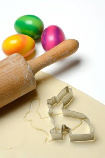 Rolled dough with bunny cookie cutter, rolling pin and Easter eggs