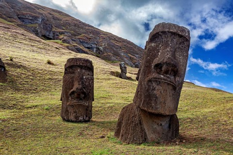 Two tilted Moai statues on a hill under cloudy sky, The Moai Statues on Easter Island in the